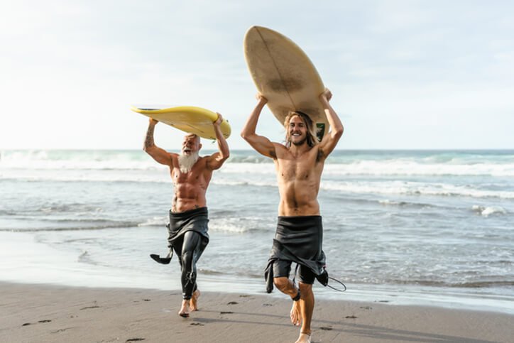 two people on beach after surfing - best joint replacement doctors in New Hampshire